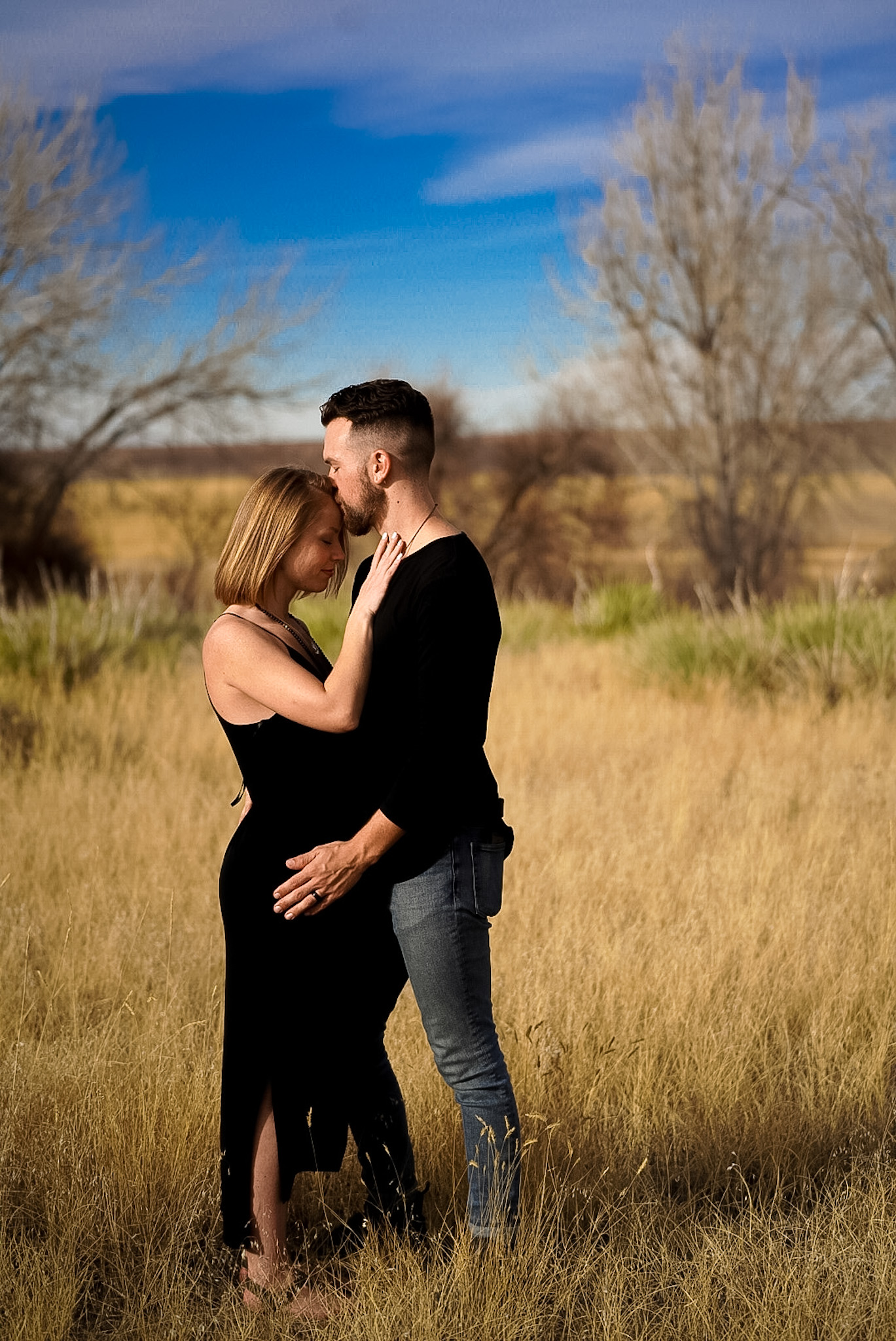 Maternity portrait of a couple in a golden field