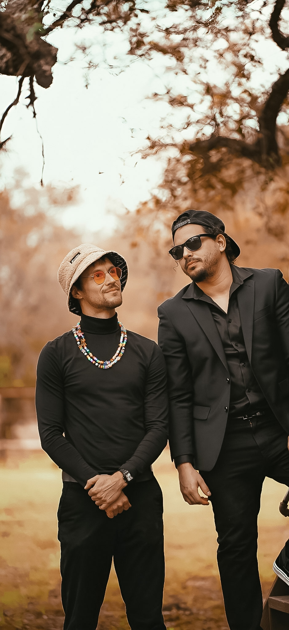 Styled duo beneath trees