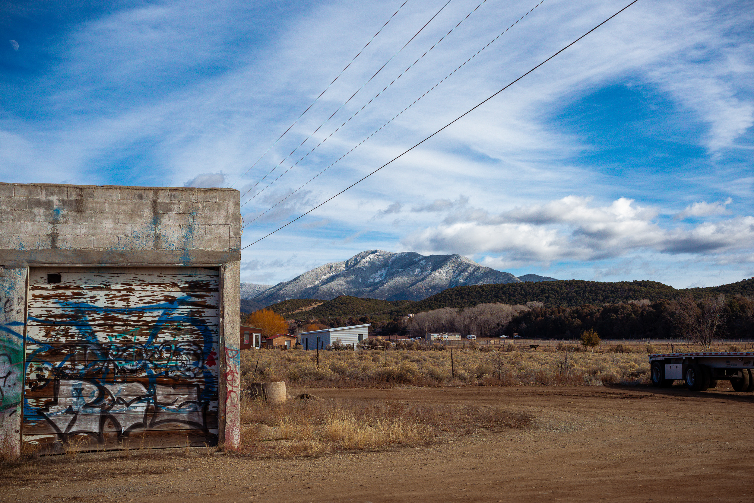 Graffiti garage beneath a Taos mountain peak