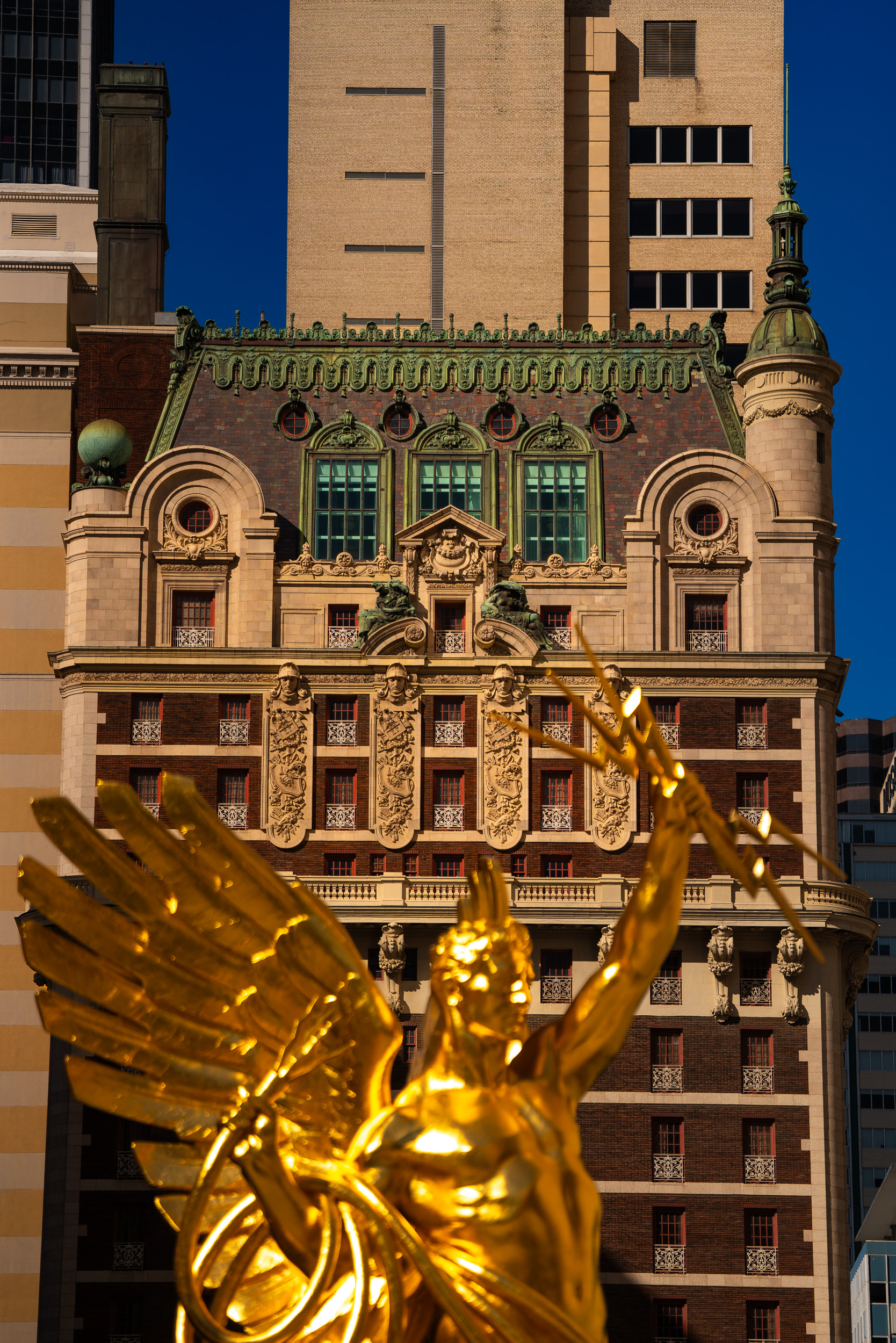 Gilded winged statue against historic Dallas facades